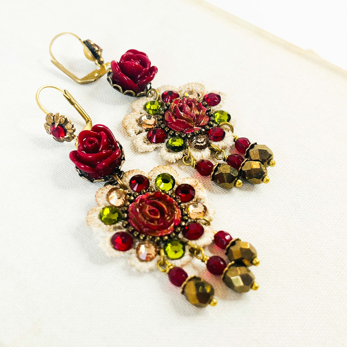 Pendientes largos de encaje bordado beige, rosas rojas y cristales de swarovski tonos beige, verde oliva y rojo. Gancho cerrado francés con flor. 