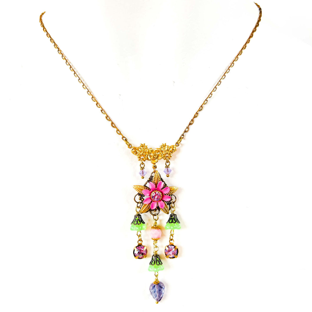 collar colgante floral en tonos rosado, dorado y verde.