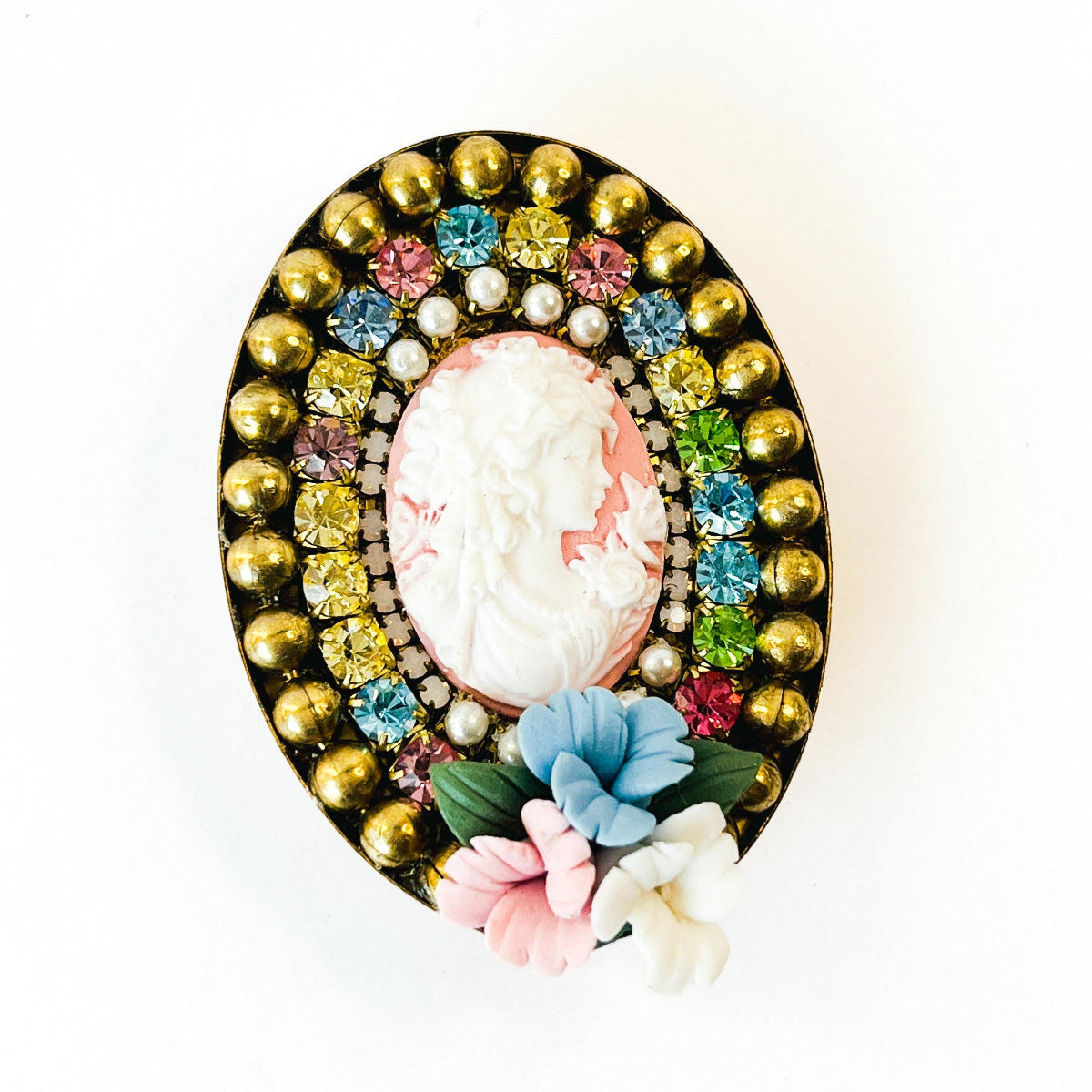 prendedor estilo camafeo con imagen de mujer, y flores de porcelana. Con cristales de Swarovski multicolor.