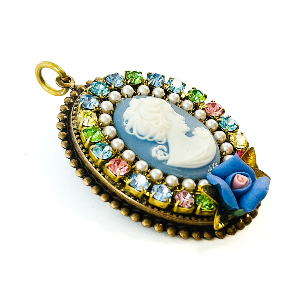 prendedor estilo camafeo con imagen de mujer, y flores de porcelana. Con cristales de Swarovski multicolor.