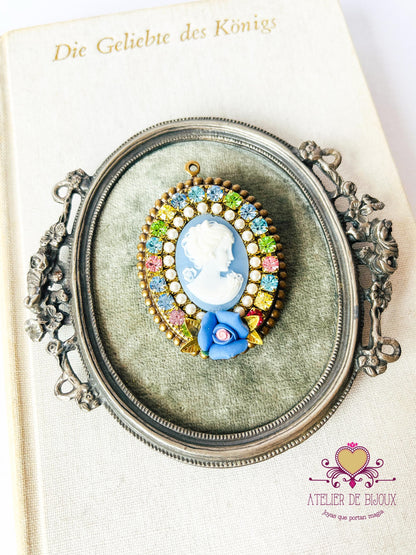 Prendedor estilo camafeo con imagen de mujer azul y rosa de porcelana. Con cristales de Swarovski multicolor. 