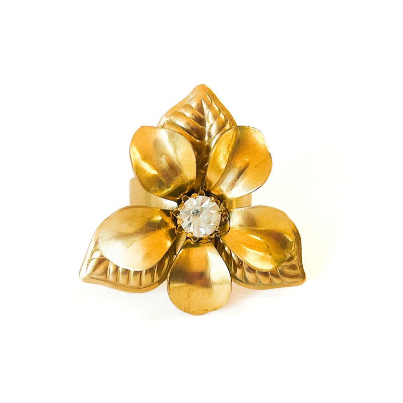 Anillo ajustable Fleur de Soleil con gran flor dorada y cristal central facetado de Atelier de Bijoux.