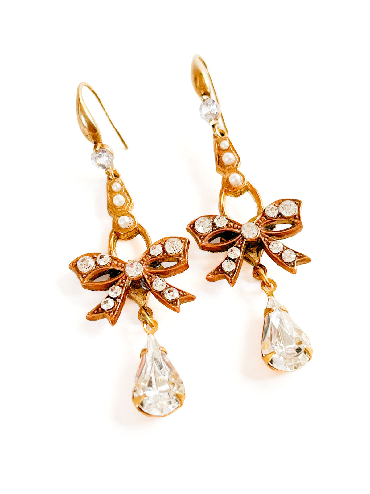 Aros Lazo de Cristal dorados con cristales transparentes, detalles perlados y lágrima facetada