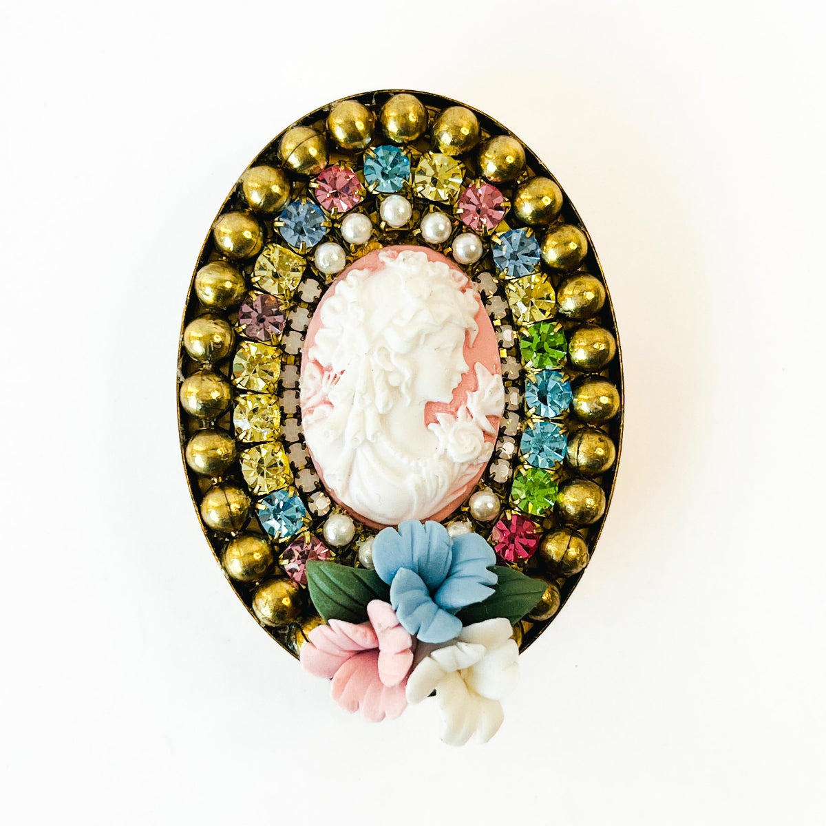 prendedor estilo camafeo con imagen de mujer, y flores de porcelana. Con cristales de Swarovski multicolor.