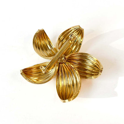 Broche flor dorada con perla central.