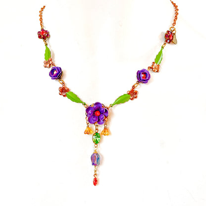 Collar Violeta Silvestre con flores violetas, hojas verdes y cristales multicolor