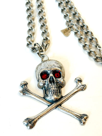 Collar calavera con tibias cruzadas, cristales rojos y cadena en tono plateado envejecido