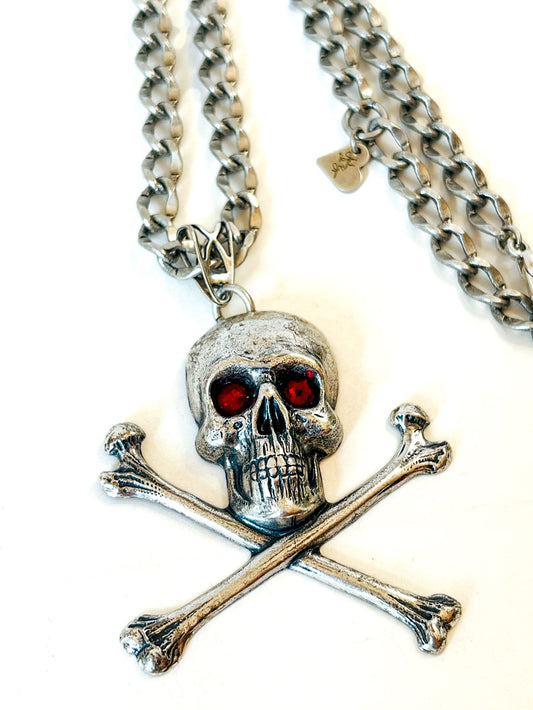Collar calavera con tibias cruzadas, cristales rojos y cadena en tono plateado envejecido