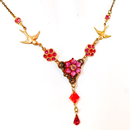 Collar floral de inspiración vintage con dos golondrinas doradas y flores fucsia