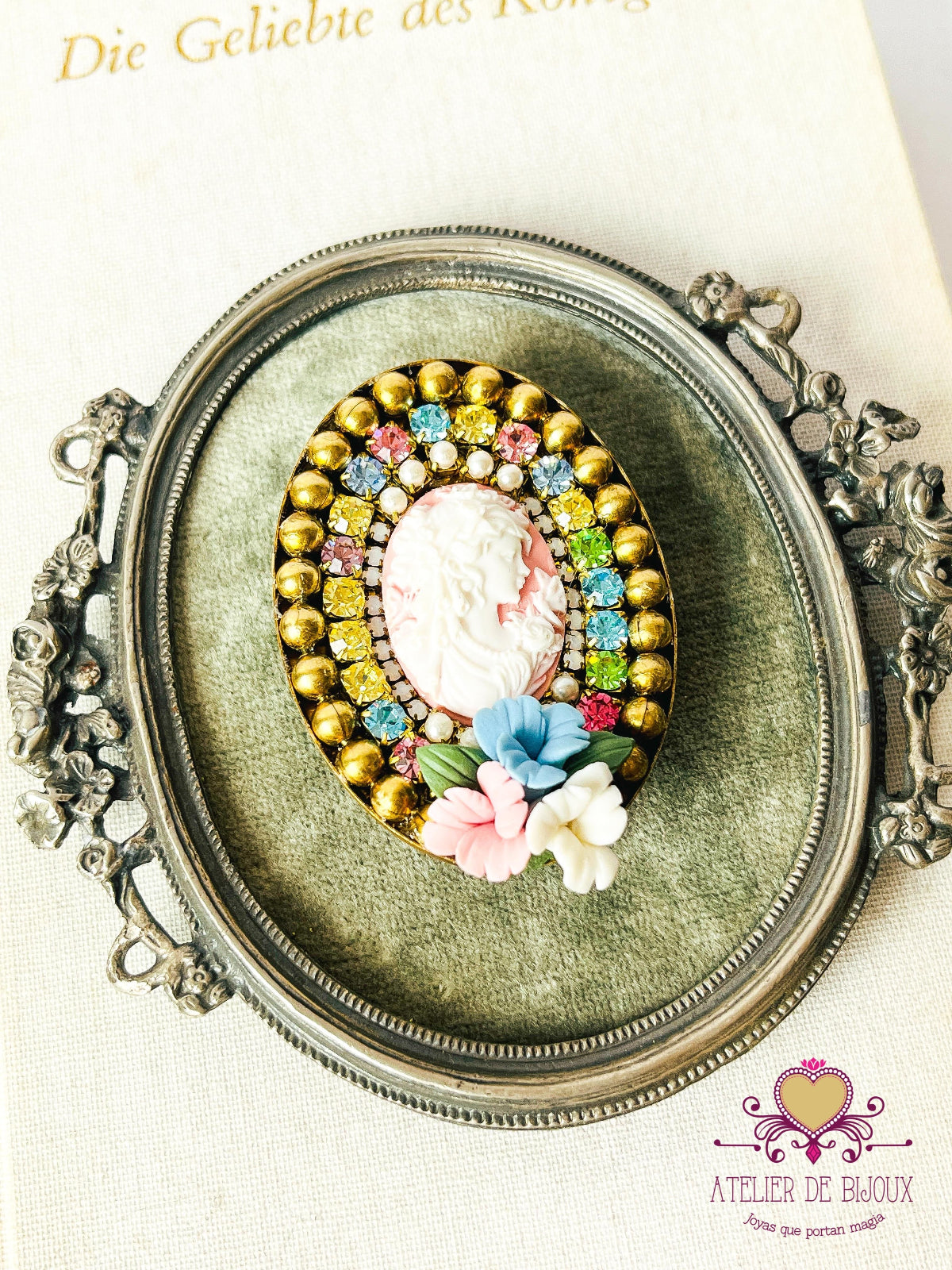prendedor estilo camafeo con imagen de mujer, y flores de porcelana. Con cristales de Swarovski multicolor.