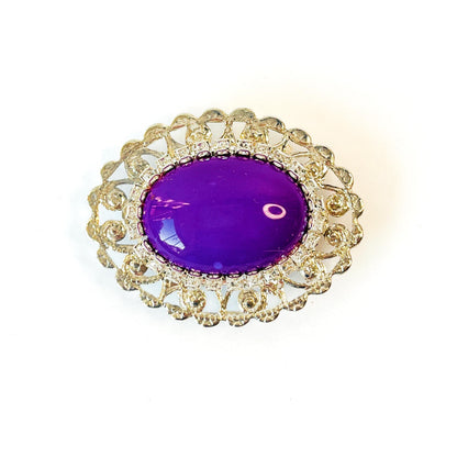 ´broche plateado y piedra morada