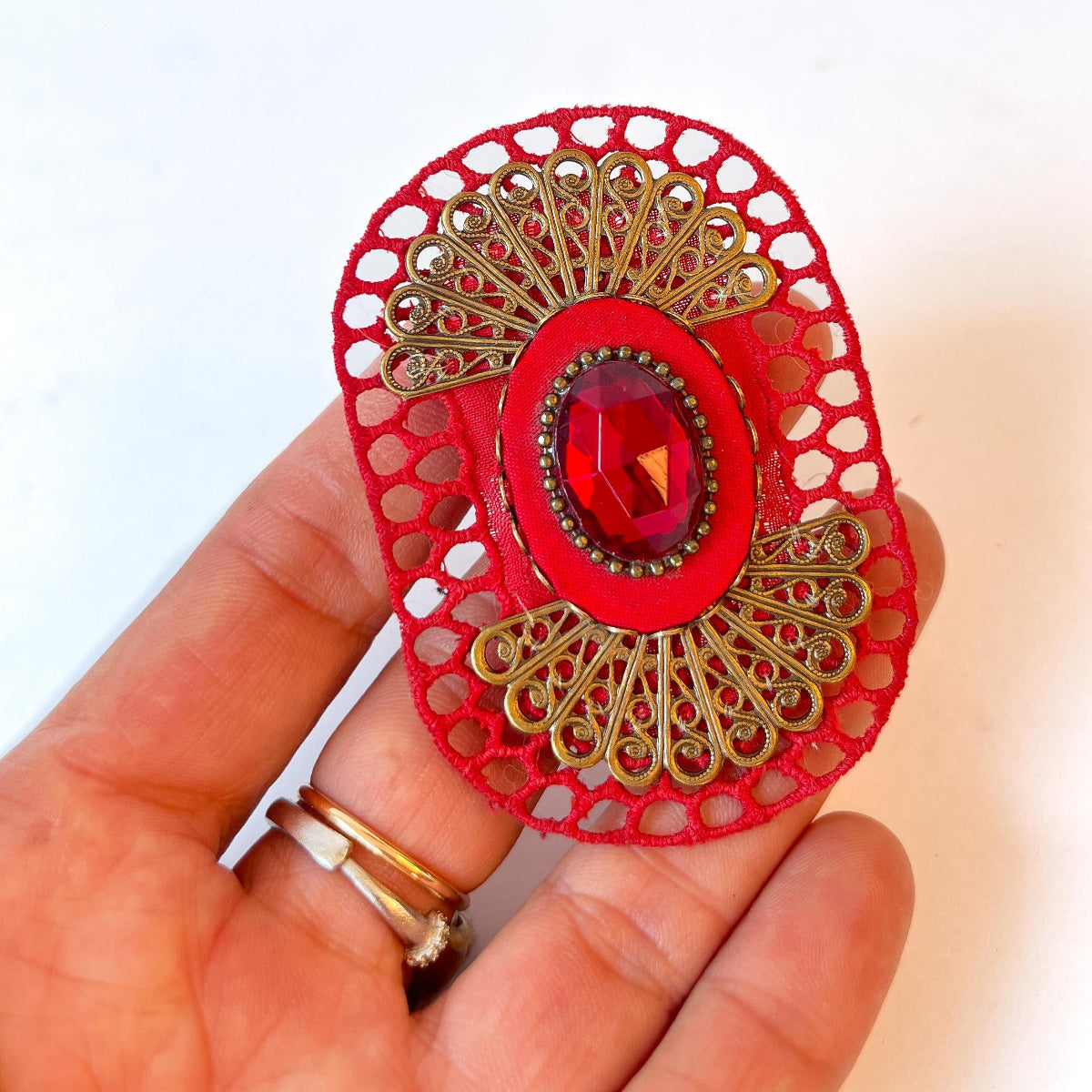 broche textil escarlata, con filigrana y cristal facetado rojo