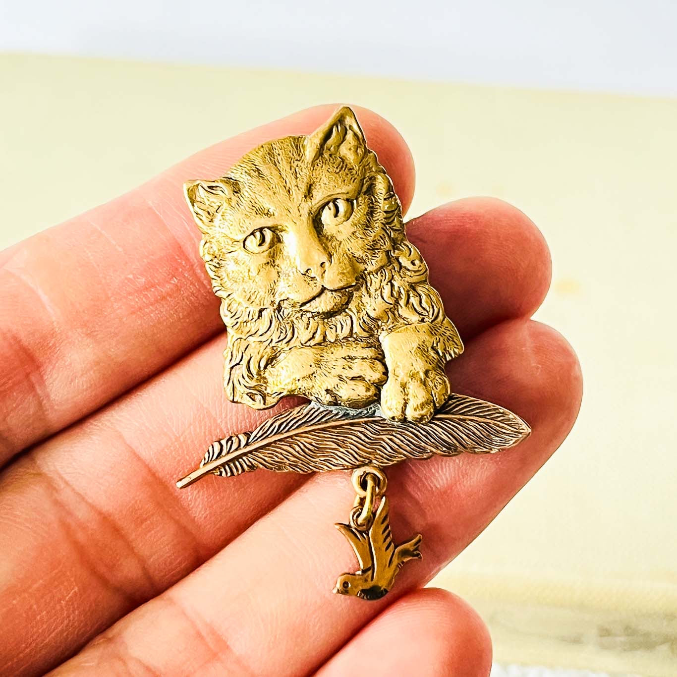 prendedor gato y pluma